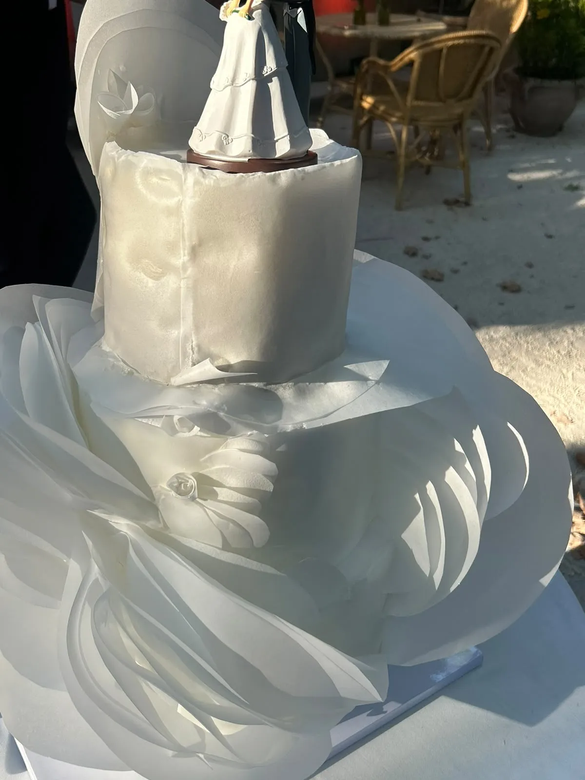 Tarta de boda de varios pisos cubierta de volantes blancos de azúcar.
