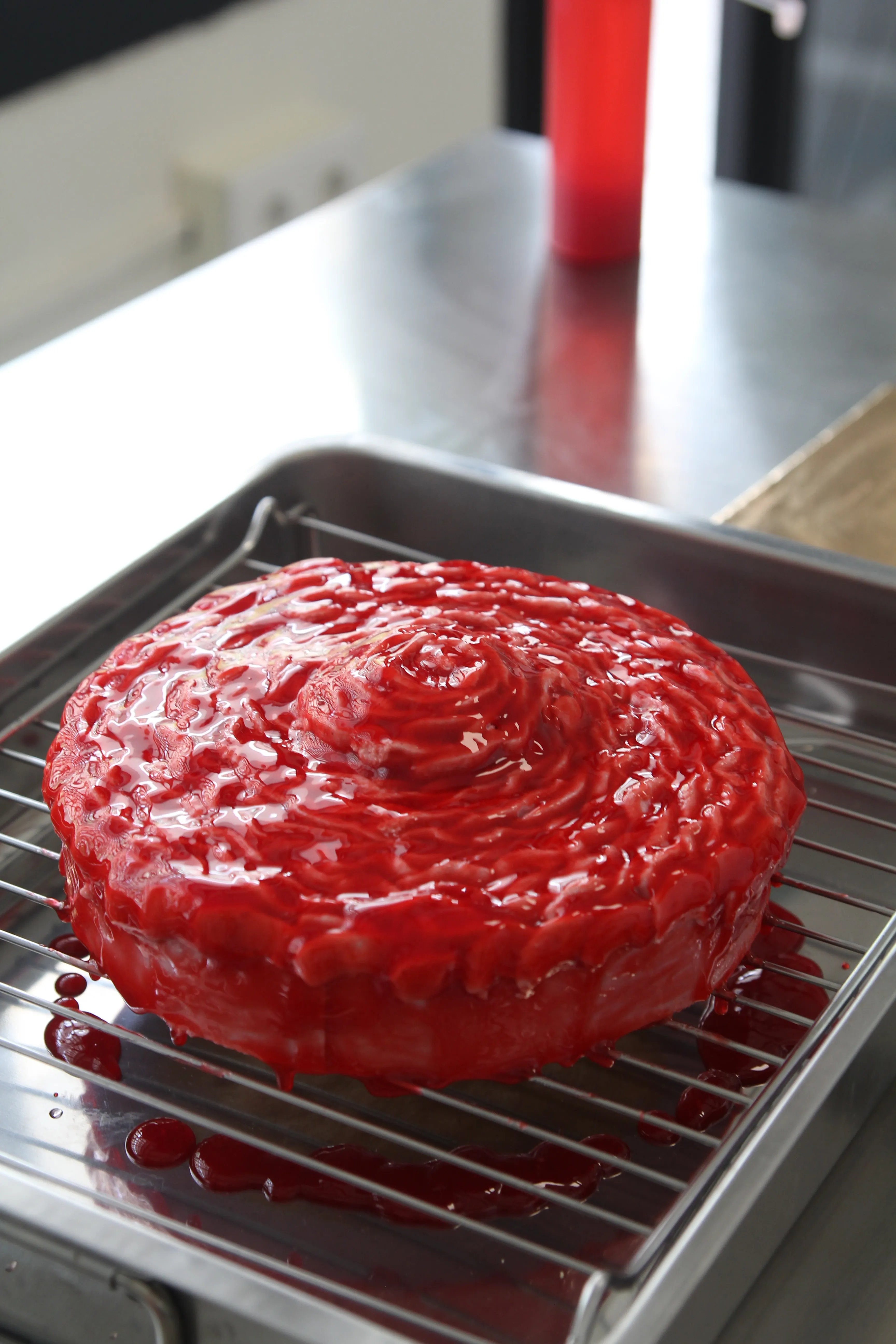 La tarta cubierta de glaseado rojo en espiral, sobre la rejilla.